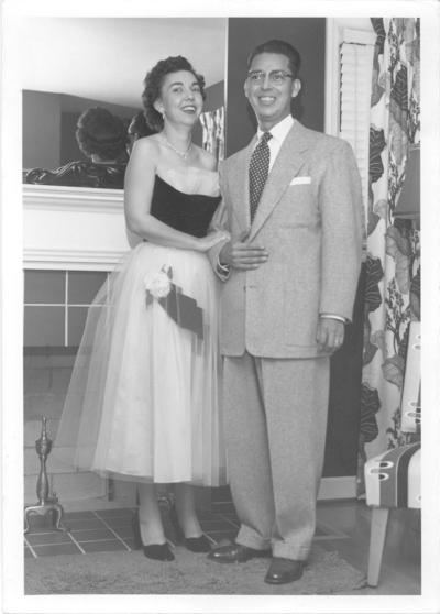 Family and Friends; A couple standing near a fireplace