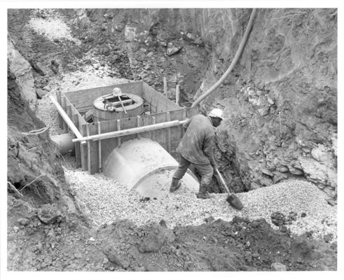 West Hickman Creek Interceptor Sewers; Construction; A man shovels gravel near a manhole station