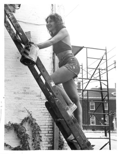 Women; Individual; Unidentified; A woman climbing a ladder