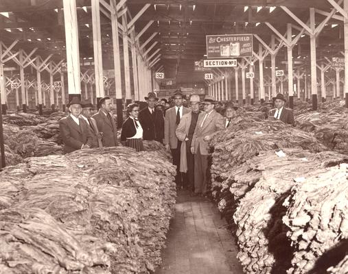 Tobacco; Several people posing in a tobacco warehouse