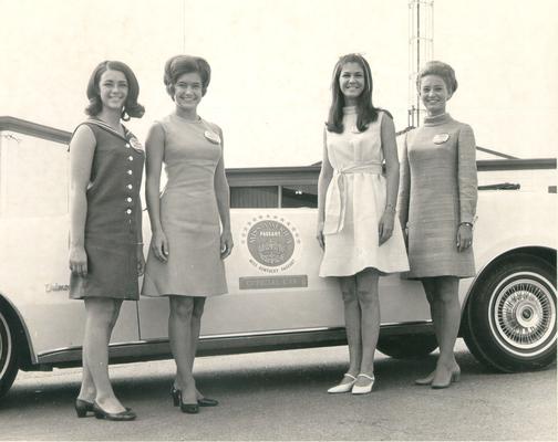 Beauty pageants; Same four contestants stand beside the car