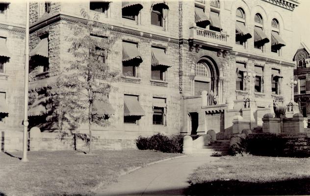 Buildings; Unidentified; Large, three-story stone building with awnings