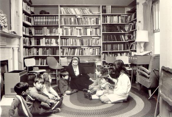 Children; A nun speaks to children in a library