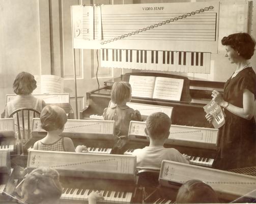 Children; And Musical Instruments; Classroom full of piano students