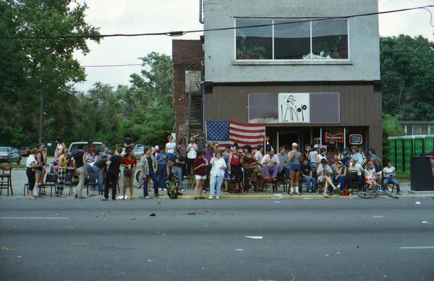 Group of parade watchers in front of Cafe LMNOP at the Lexington Fourth of July parade