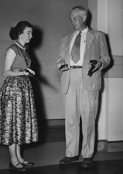 Coleman, J. Winston, Jr., Alumnus, Bachelor of Science in Mechanical Engineering, 1920; Master of Science in Mechanical Engineering 1929; Litt.D., 1947, Engineer, Author, Historian, Collector, pictured with unidentified woman displaying antique handguns