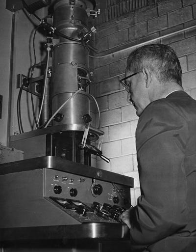 Edwards, Ogden Frazelle, Professor of Bacteriology, Biological Sciences Department?, pictured with electron microscope