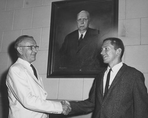 Gibson, John, Alumnus, pictured (right) receiving Graham Scholarship from unidentified individual, August 1964, Public Relations Department
