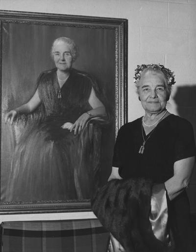 Holmes, Sarah Bennett, born 1886, University of Kentucky Dean of Women 1944-1957, standing by her portrait in the lobby of Holmes Hall- Women's Dormitory