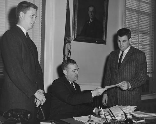 Host, Jim, from left to right, Jim Host, K-club member and secretary of the club; President Frank Dickey; Lawson King, member of the club; the students were giving the President money for the Indonesia project in 1959