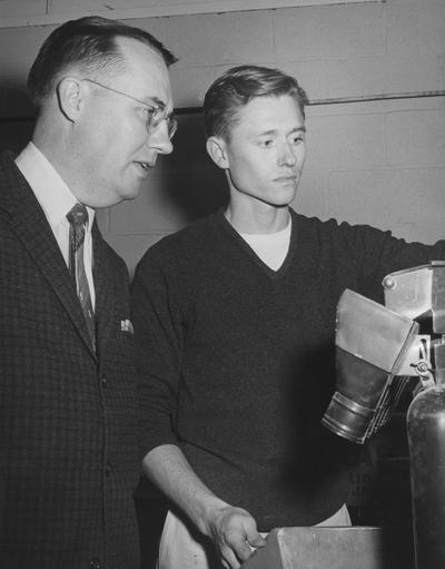 Howard, Jack B., of Tompkinsville, has studied mining engineering at the University of Kentucky for five years, with a scholarship from the industry, he currently is working on his M. S. degree with a $2400 grant from the Consolidation Coal Company, Dr. Ernest Spokes, professor of mining engineering, observes Jack testing the practicability of recovering more coal through the use of an air table which separates heavy and light minerals, Public Relations Department