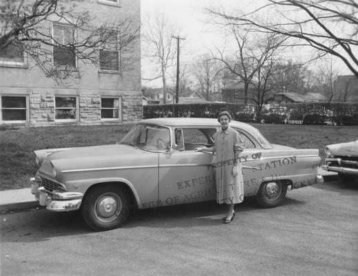 Lewis, Rachel J., Associate H.D.A. Fayette County 1952-1957, posed in front of car in front of Agriculture Building