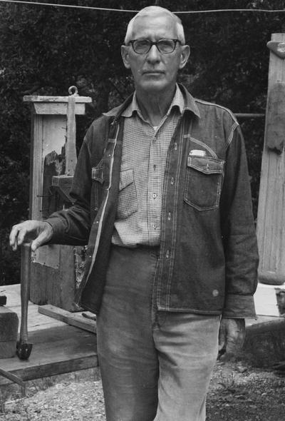Barnhart, Raymond C., Professor, Department of Art, standing outdoors with his sculptures, photographer: Gen Barnhart