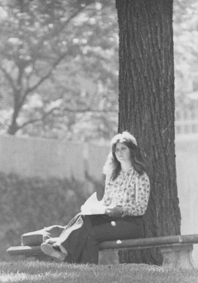 Middleton, Yolanda, a Univeristy of Kentucky Junior majoring in Interior Design who is reviewing her notes on a bench under a tree on campus, Photographer: University Information Services