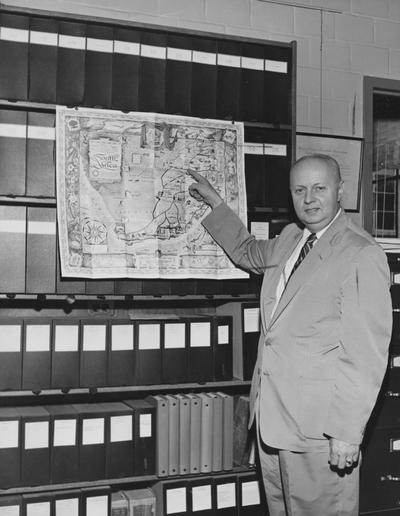 Riley, Herbert, Distinguished Professor and Head of Botany, to leave Monday for Africa on a tour which will take him to Pretoris, Union of South Africa, where he will be engaged in teaching and research for a period of nine months, he is pictured pointing to the location of the University of Pretoria, the institution to which he will be attached while in Africa