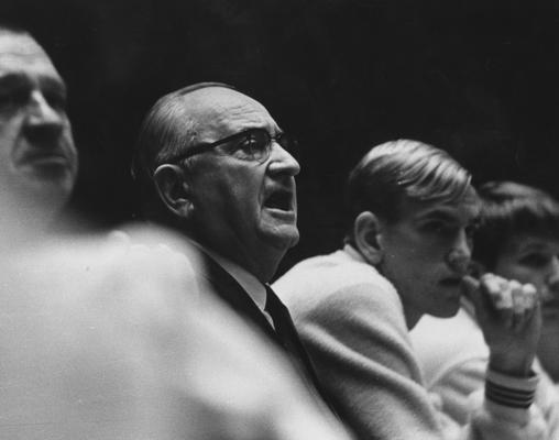 Rupp, Adolph, University of Kentucky Basketball Coach 1930-1971, Rupp at game sitting on bench