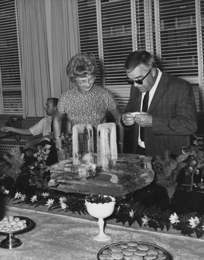 Seward, Doris, Dean of Women and Professor of Education, pictured with Mr. Kerky with Ice Sculpture of the Kirwan Blanding Complex