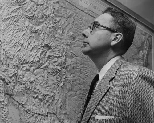 Boyer, Robert, Professor, Chemistry Department, looking at large wall map, noted 