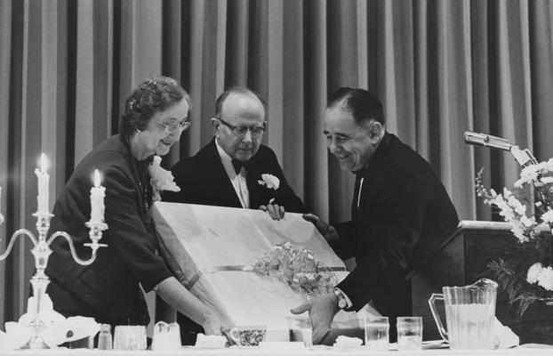 White, Martin, Dean of College of Arts and Sciences, pictured receiving a gift from President Oswald (right) the woman to the left is probably Mrs. White, occasion is probably Dr. White's stepping down from Dean
