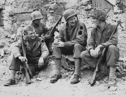 Whitehead, Don, Associated Press War Correspondent, received Honorary Degree in 1948, pictured sitting in army uniform talking with United States Troops in the ruined town of St. Andre de Lepine, from Public Relations Department