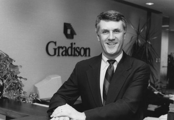 Williams, Rick, seated at a desk with this inscription on the wall: Grandison Corporation