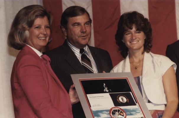 Collins, Martha Layne, 1959 graduate and Governor of Kentucky 1983-1987, pictured presenting award to Dr. Sally Ride, Astronaut with NASA, she was a mission specialist on the second flight of the Orbitor Challenger's six day mission, from left to right; Lieutenant Governor of Kentucky, Collins; United States Senator, Walter 
