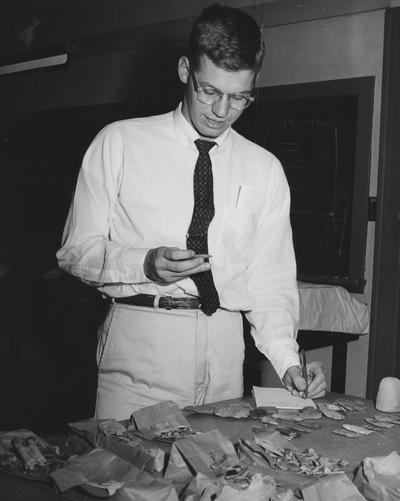 Unidentified, Man is pictured examining rocks from Barkley Dam area