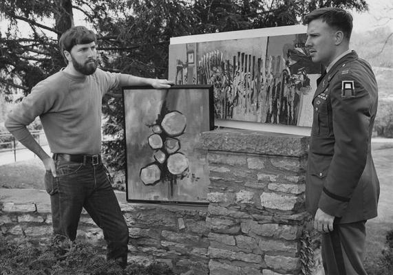 Channon, Captain James B., Professor, Military Science, pictured with fellow Vietman veteran and University art student Mike Lane (left), both displaying their paintings, which were part of an exhibit at Turfland Mall (Lexington)