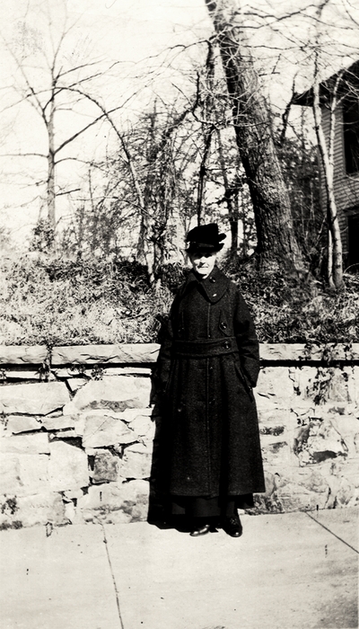A portrait of an unidentified woman standing on a sidewalk (possibly Margaret Ingels' mother). Taken by De Lure Studio, Hot Springs, Arkansas. This print was found pasted to the back of page 108 of 