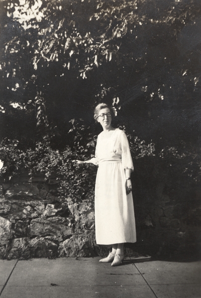 A portrait of an unidentified woman standing across from a Y. W. C. A. (Young Women's Christian Association) residence. This print was found pasted to the front of page 109 of 