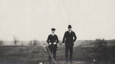 An image of two unidentified men posing on a golf course. This print was found pasted to the back of page 114 of 