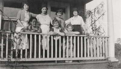 A group portrait of unidentified women posing on a porch. This print was printed by the Elizabeth Novelty Co. 923 Elizabeth, N. J. This print was found among the 