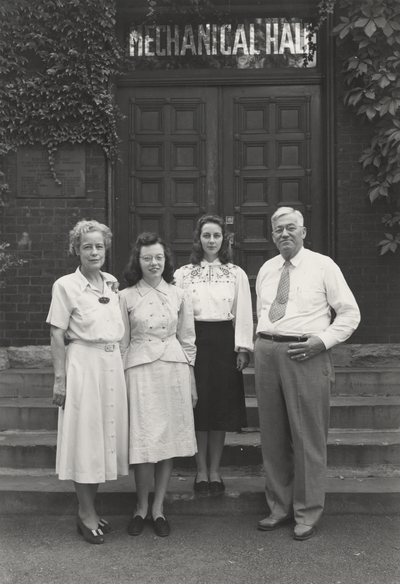 A group portrait of Margaret Ingels, Betty Carolyn Peters, Jessie Marie Kempier and Dean Dan V. Terrell standing front of the entrance to Mechanical Hall on the University of Kentucky campus