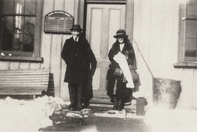 An image of Charles Christopher Schrader and Margaret Ingels standing on the steps of a train station. This print was found pasted to the front of page 115 of 