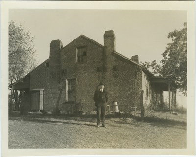 J. Winston Coleman, Jr. standing in front of the Rankin House located in Ripley, Ohio on Liberty Hill which overlooks the Ohio River. Owned by Reverend John Rankin and used as a way station for the Underground Railroad; written on back: 
