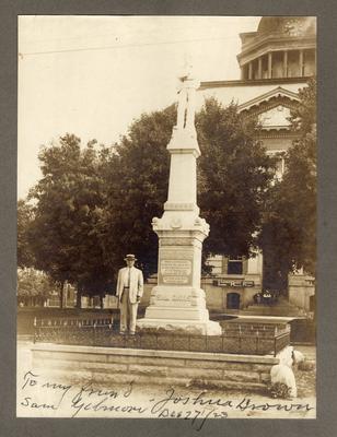 Portrait of Joshua Brown in civilian clothes, standing by a monument of Sam Davis with note at bottom of photo: 