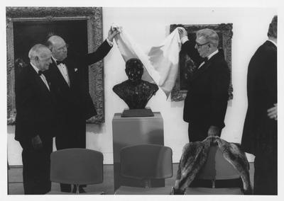 Armand Hammer, left, Bill Sturgill, second from left, and James Stewart, right, are unveiling the bust of Armand Hammer at the opening of the Armand Hammer exhibit in the Art Museum in the Singletary Center; James Stewart is the sculptor and Bill Sturgill was chairman of the University of Kentucky Board of Trustees