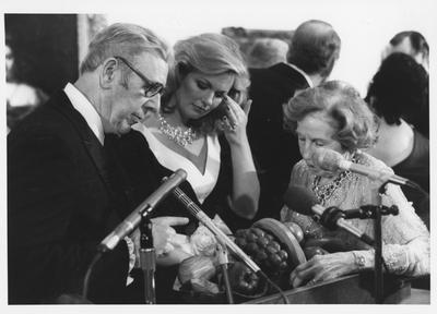 James Stewart, left; Phyllis George Brown, center, spouse of Governor John Y. Brown, Jr.; and Mrs. Armand Hammer, right; admire a sculpture at the opening of the Armand Hammer exhibit in the Art Museum in the Singletary Center; James Stewart is the sculptor