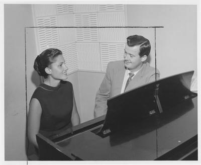 James Kerig (right) and an unidentified woman sit at a piano