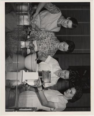Members of Phi Epsilon Omicron, the women's Home Economics honorary society, make fruitcakes; From left to right: Martha Ann Hurt, Kris Ramsey, Teena Fredrickson, and Wilma Basham