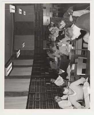 Students study in the Law Library; Includes Robert E. Adams (seated, front, in sweater); Gene Oliver (seated, second table, head on hand); and Joseph E. Johnson III (second from front along left wall)