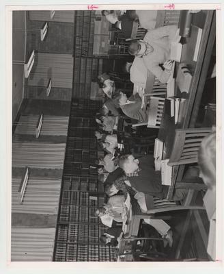 Students study in the Law Library; Gene Oliver, first table on far left, hand to head