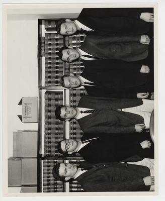 Law students in the Law Library; From left to right: Bill Fortune, Bill Minogue, Joe Savage, Sam Whitehead, and two unidentified men