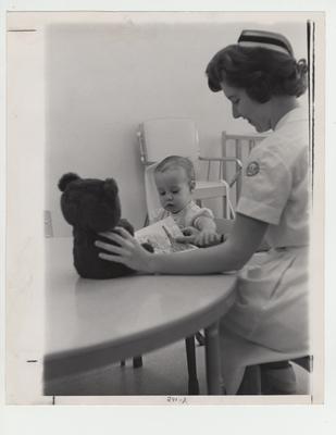 Linda Enslen, student nurse, entertains a child; This image is on page 291 of the 1963 Kentuckian