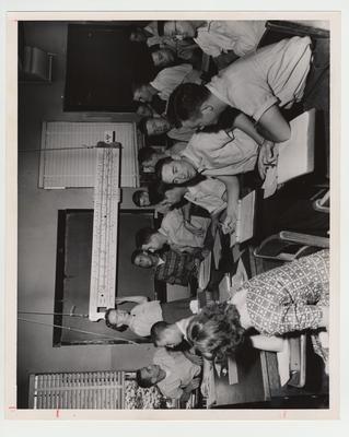 Ruth Brookner instructs a class in how to use a slide ruler; Ashland Center, Ashland, Kentucky
