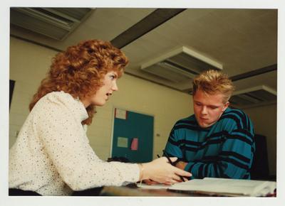 A woman helps a male student in a classroom at Ashland Community College