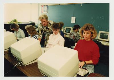 A female professor helps female students in a computer lab