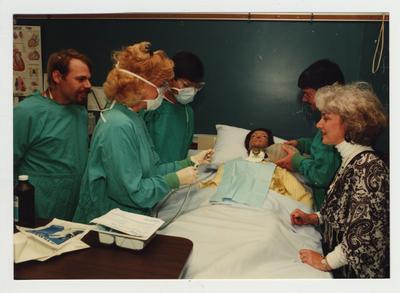 Students perform a medical treatment on a mannequin