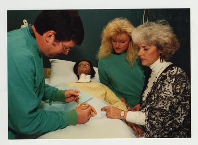 Students perform a medical treatment on a mannequin