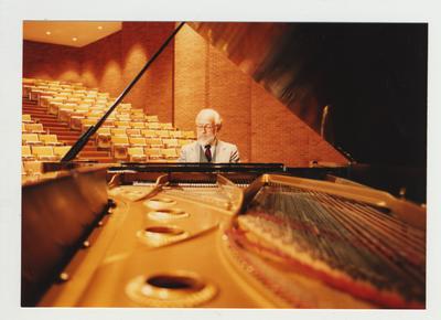A man plays the piano in an auditorium